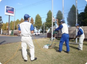 芝刈り機で芝を整備中