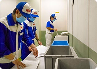 奥:シュレッダー裁断 / 手前:ホッチキスを外し裁断しやすいように並べる作業