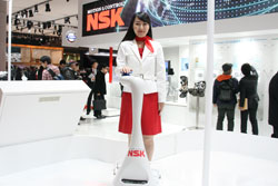 A model demonstrates LIGHBOT™, an NSK obstacle avoidance guide robot for the visually impaired.