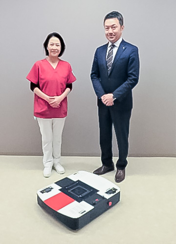 今回実用化した搬送アシストロボットと湘南鎌倉総合病院 駒谷師長(写真左)、NSK事業企画本部 杉浦副主務(写真右)